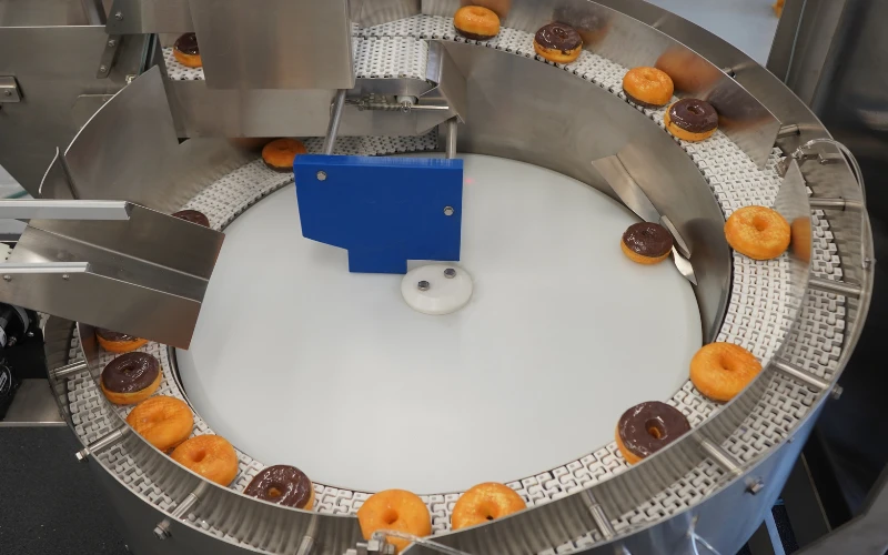 Overhead view of ultimate orienting conveyor demo running donuts for Pack Expo International